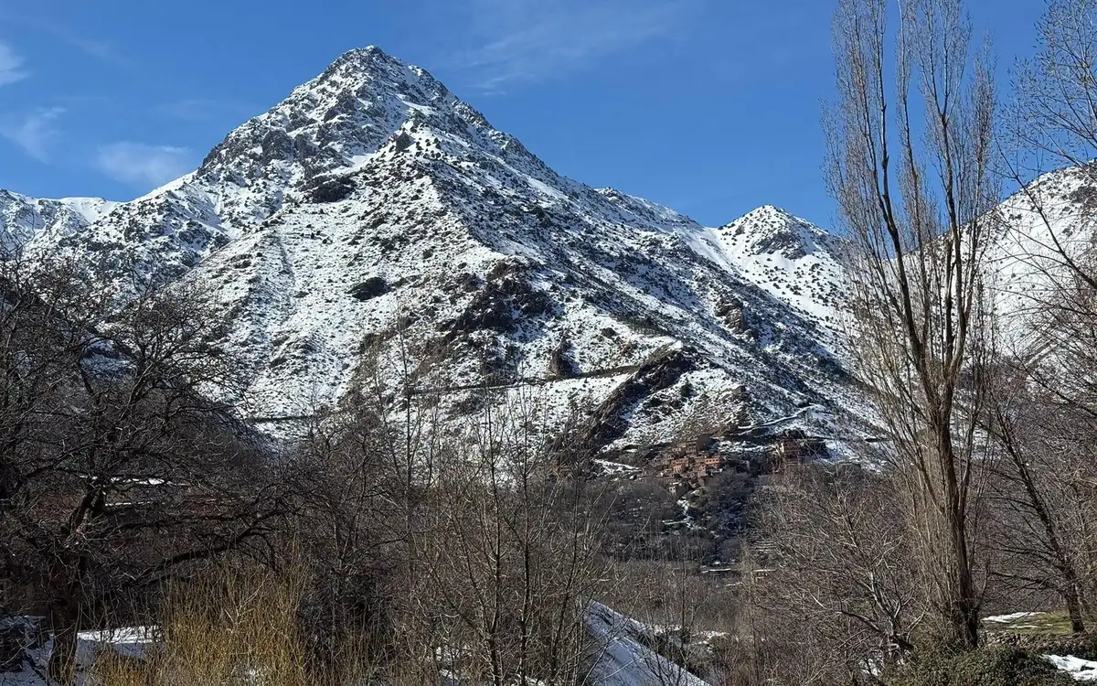A snow-covered mountain peak under a blue sky