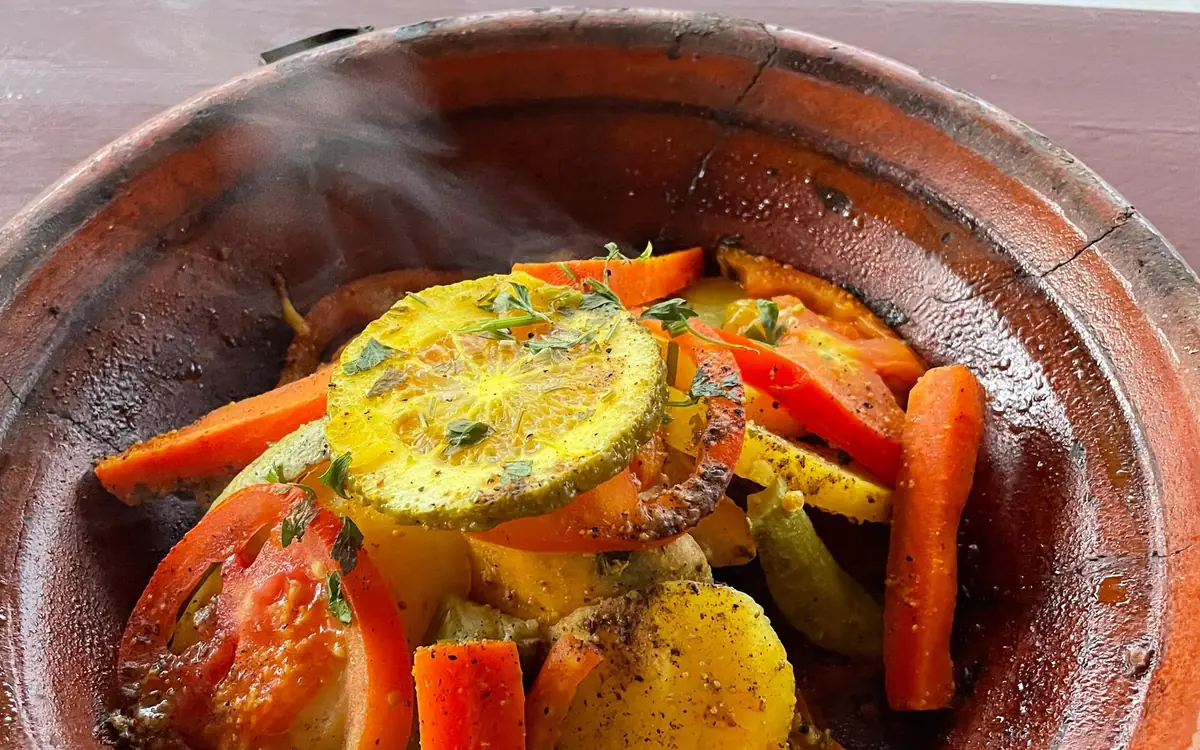 A vegetable tagine with carrots and potatoes in a clay dish